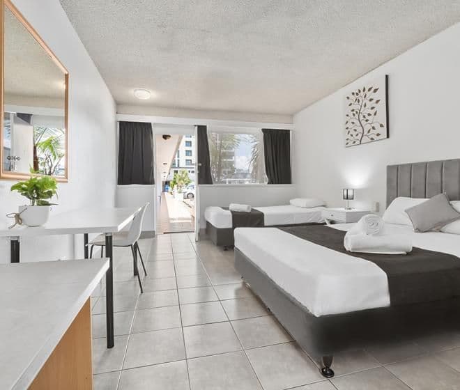 Pet friendly hotel room with multiple beds and tiled floor on ground floor.