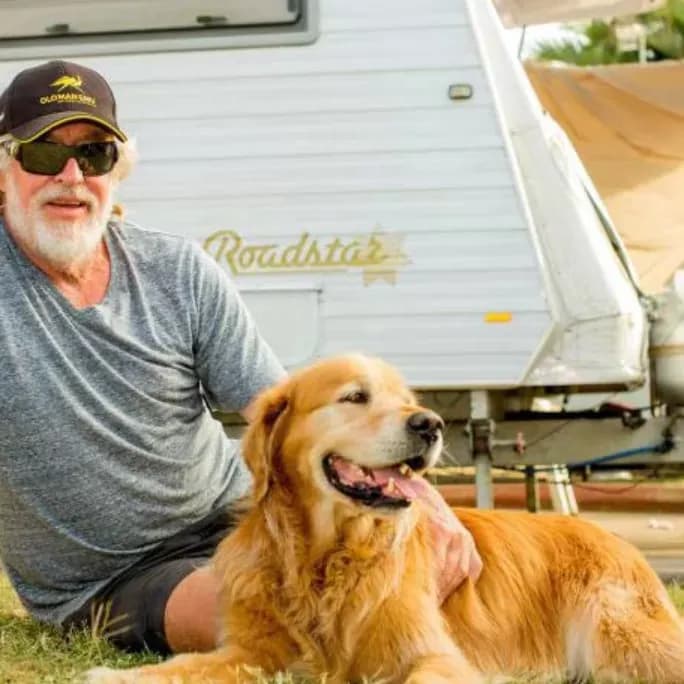 Dog with male owner relaxing at caravan park in Townsville