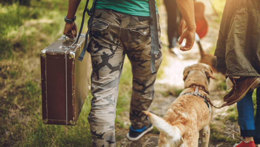 Man walking with Labrador with suitcase in and ready to go on holiday