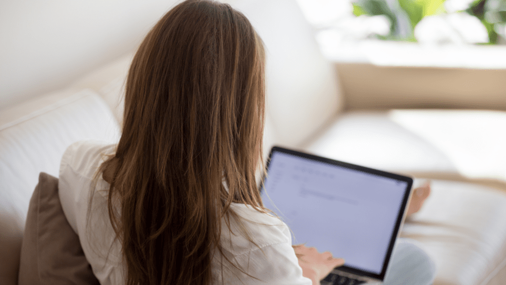 Focused woman typing on a laptop, creating engaging content for her blog.
