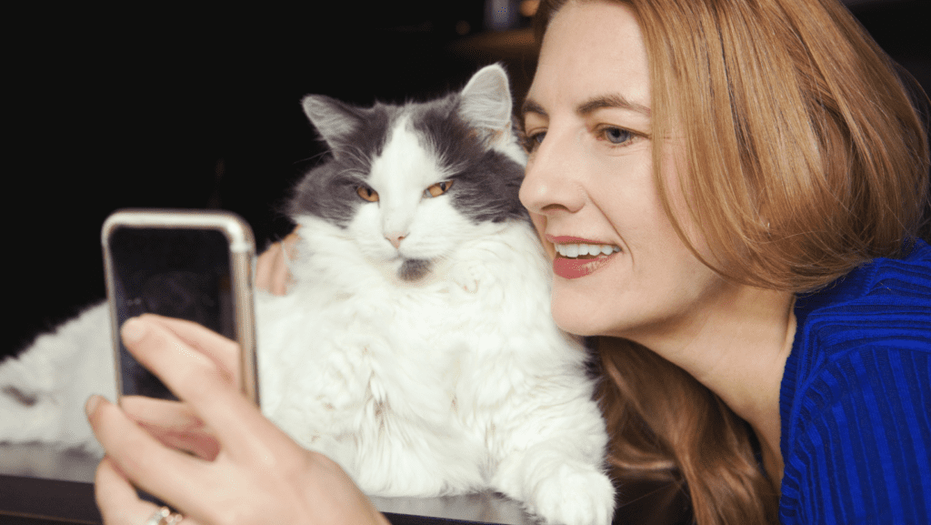 Stylish lady with a cat, capturing a selfie with a touch of sophistication.