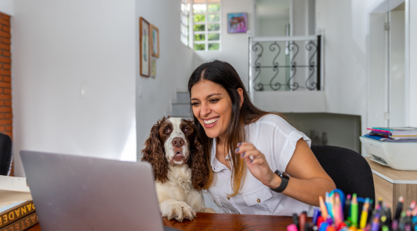 Happy lady with dog on laptop learning.